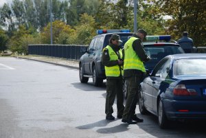 Fot. MOSG Funkcjonariusze Straży Granicznej sprawdzają dokumenty kierowcy zatrzymanego do kontroli drogowej.