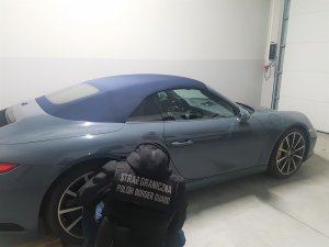 Fot. MOSG Funkcjonariusz SG przy zatrzymanym skradzionym porsche.