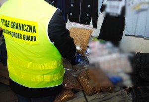 Fot. MOSG Funkcjonariusz SG zabezpiecza zatrzymane papierosy i krajankę tytoniową.