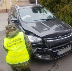 Fot. MOSG Funkcjonariusz Straży Granicznej przy zatrzymanym pojeździe.