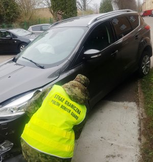 Fot. MOSG Funkcjonariusz Straży Granicznej przy zatrzymanym pojeździe.
