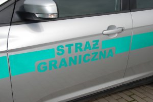Fot. MOSG Napis Straż Graniczna na drzwiach pojazdu służbowego.