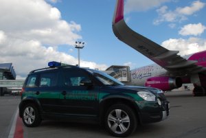 Fot. MOSG Pojazd służbowy SG na płycie lotniska w Gdańsku.. W tle samolot Wizzair.