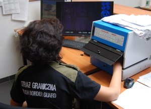 Fot. MOSG Funkcjonariuszka analizuje dokument przy użyciu specjalistycznego urządzenia.