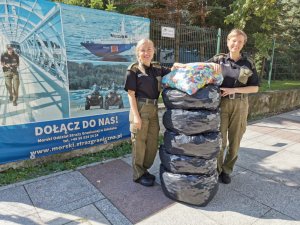 Fot. MOSG Funkcjonariuszki Straży Granicznej z Kołobrzegu przekazują worki z plastikowymi nakrętkami.