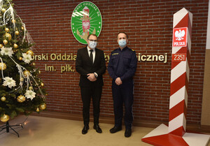 Fot. Ł. Zwoliński Komendant MOSG i p.o. Okręgowego Inspektora Pracy stoją przy ścianie z napisem Morski Oddział Straży Granicznej.