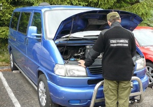 Fot. MOSG Funkcjonariusz Straży Granicznej przy zatrzymanym volkswagenie transporterze