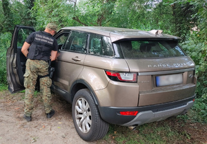 Fot. MOSG Funkcjonariusz SG otwiera drzwi samochodu Range Rover Evoque.
