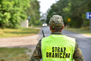 Fot. A. Kubiak Funkcjonariusz SG stoi na drodze, typując pojazdy do kontroli.