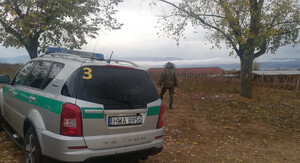 Funkcjonariusz SG podczas patrolu w Macedonii. Funkcjonariusz SG podczas patrolu w Macedonii, w tle zatrzymani migranci.