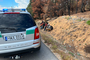 Samochód SG podczas patrolu w Macedonii, w tle zatrzymani migranci. Funkcjonariusz SG podczas patrolu w Macedonii, w tle zatrzymani migranci.