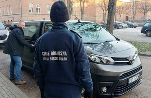 Funkcjonariusze załadowują mlekiem samochód. Funkcjonariusze załadowują mlekiem samochód.
