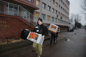 Funkcjonariusze przenoszą kartony z rzeczami dla dzieci Funkcjonariusze przenoszą kartony z rzeczami dla dzieci