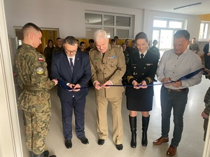 Dyrektor szkoły z gośćmi przecinają wstęgę Dyrektor szkoły z gośćmi przecinają wstęgę