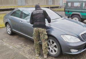 Funkcjonariusz Straży Granicznej przy zatrzymanym mercedesie. Funkcjonariusz Straży Granicznej przy zatrzymanym mercedesie.