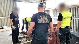 Funkcjonariusze podczas przeszukania ładunku z narkotykami. Funkcjonariusze podczas przeszukania ładunku z narkotykami.