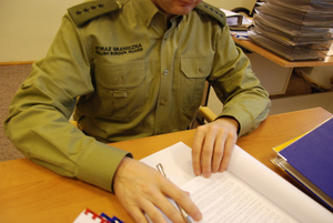 Funkcjonariusz analizuje dokumentację. Fot. MOSG Funkcjonariusz analizuje dokumentację. Fot. MOSG